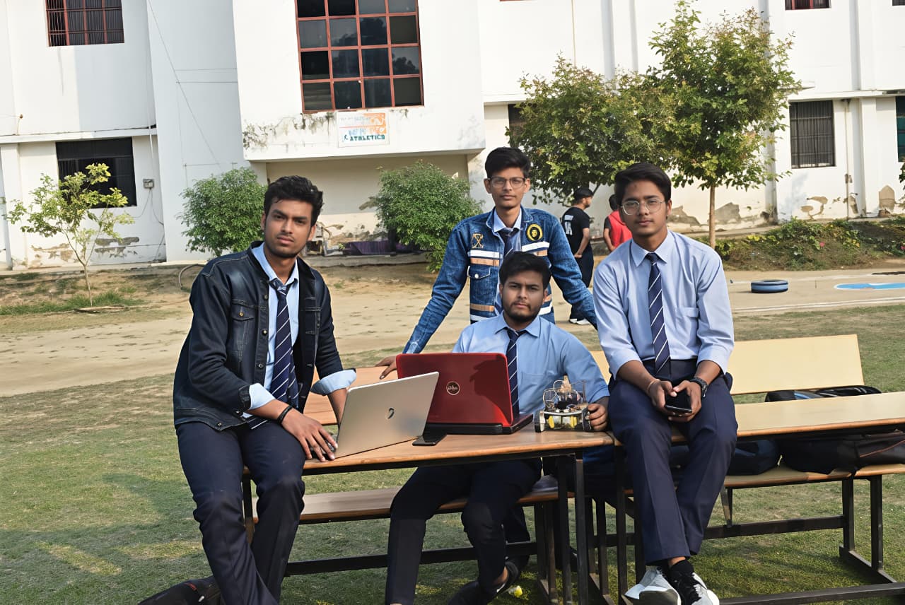 Team working on robotic car with laptops outdoors